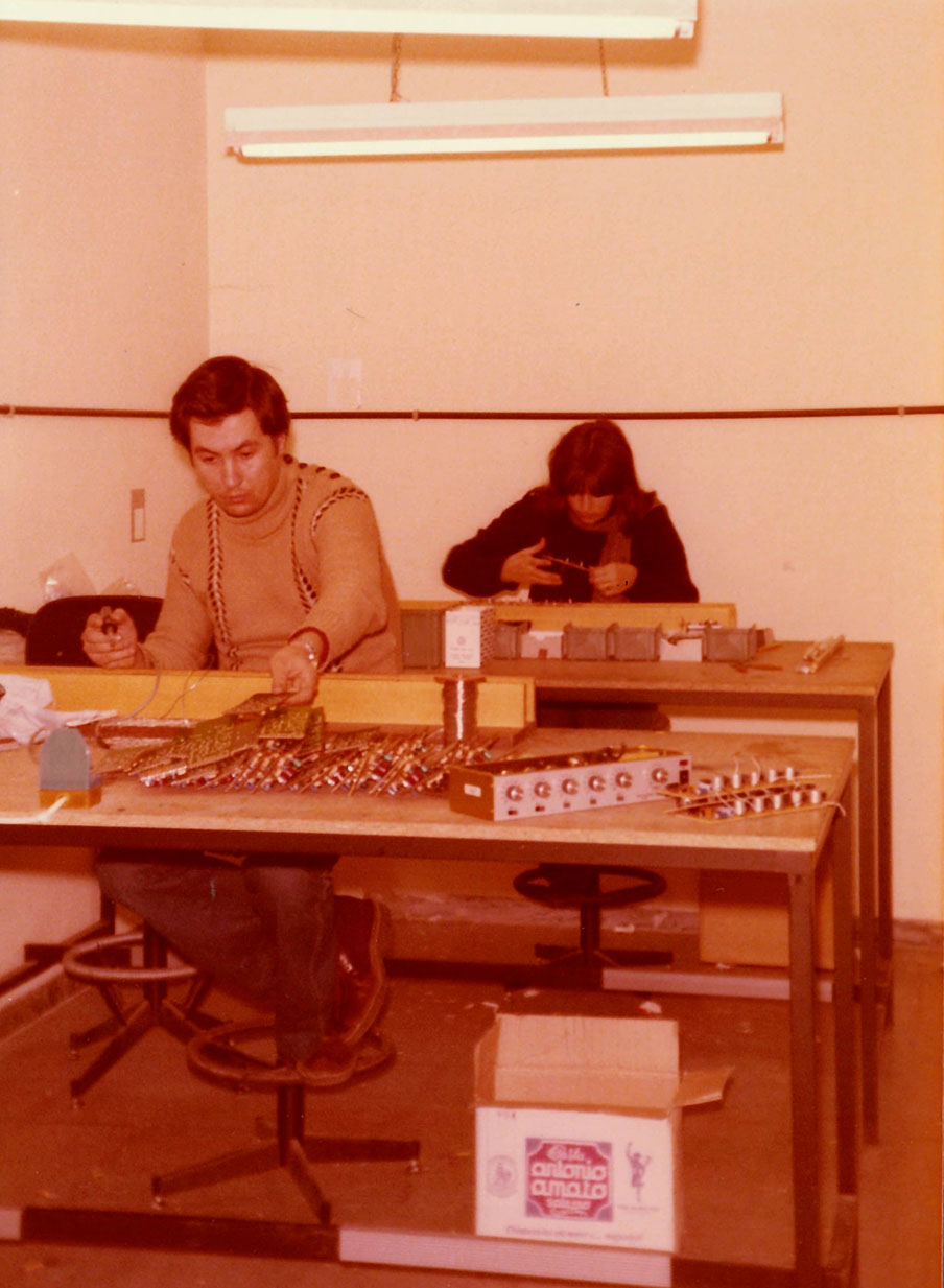 Foto d'epoca che ritrae due operatori intenti a lavorare su schede elettroniche.